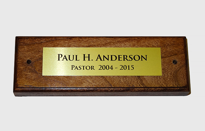 Custom wood plaque for portrait. Wood plaque measures 2 in. x 6 in. in cherry with a dark stain and finish. Gold plate measures 1 in. x 4 in.